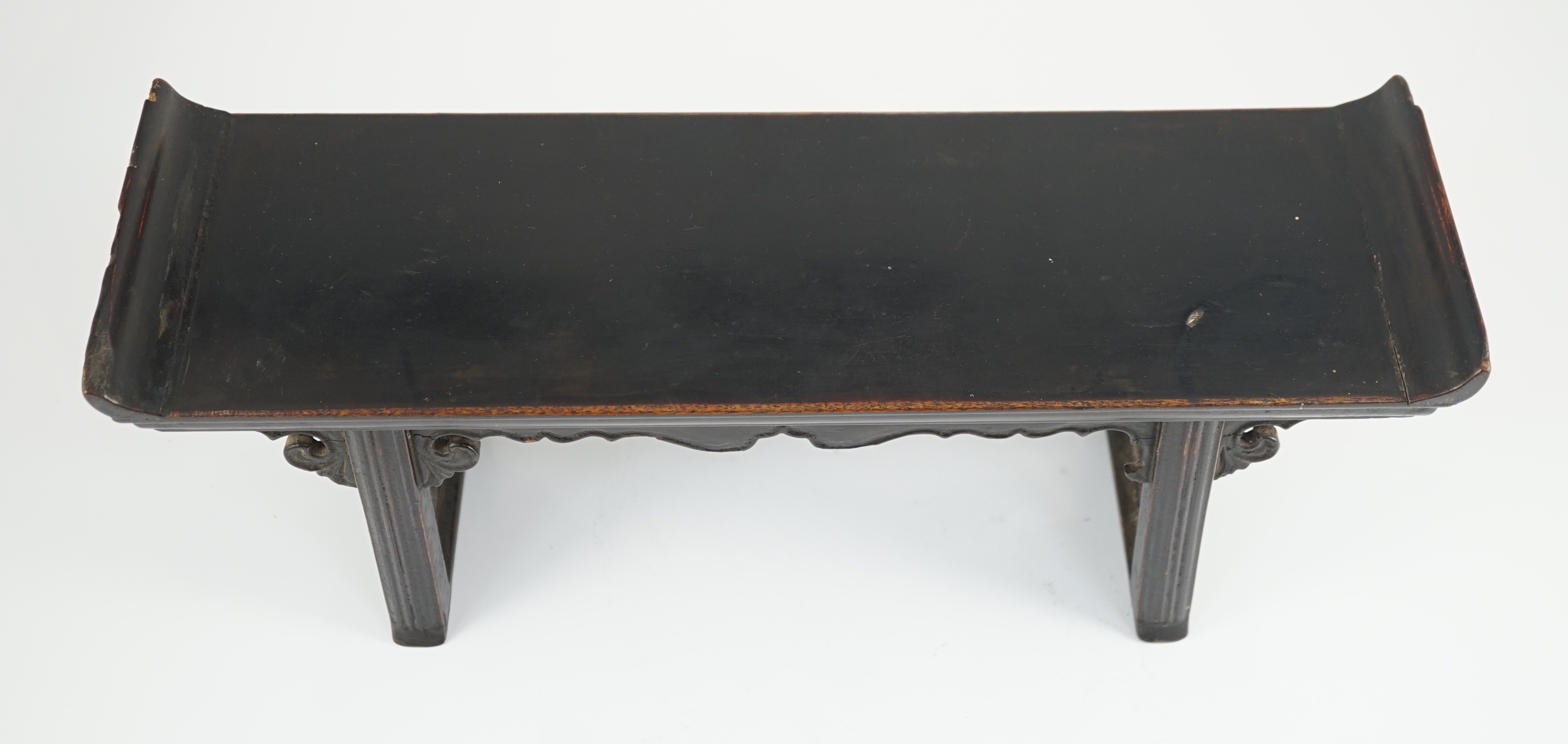 A Chinese late Ming lacquered wood model of an altar table, 17th century, 41cm wide, 16.5cm high, minor losses